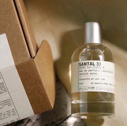 Santal 33 perfume bottle with a brown box on a wooden surface